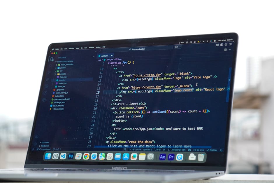 Close-up of a laptop screen displaying a dark-themed code editor with lines of JavaScript and HTML code related to app development, including functions, div elements, image tags with alt attributes, a